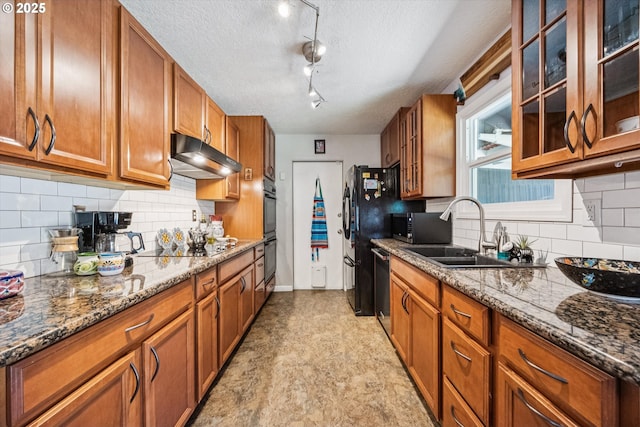 1903 SE 158th Ave, Portland, OR 97233 - kitchen with under cabinet range hood, brown cabinets, dishwasher, dark stone countertops, and a textured ceiling