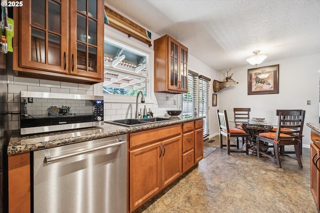 1903 SE 158th Ave, Portland, OR 97233 - kitchen featuring appliances with stainless steel finishes, brown cabinetry, backsplash, glass insert cabinets, and a textured ceiling