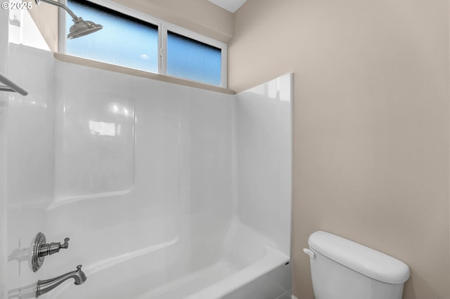 bathroom with bathing tub / shower combination and toilet