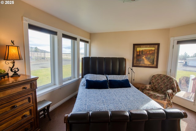 bedroom with dark colored carpet and baseboards
