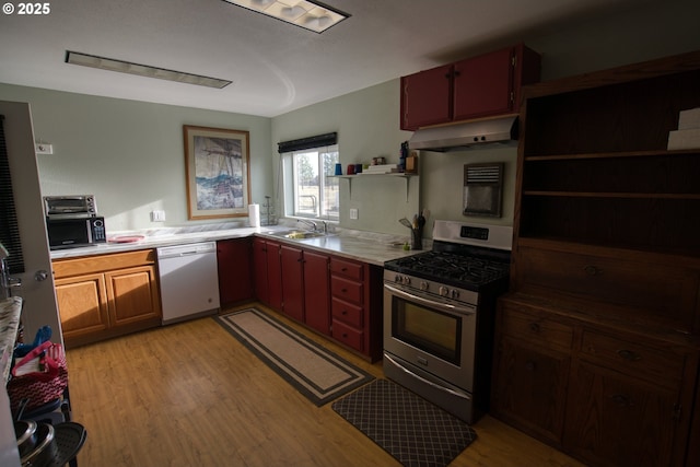 kitchen with open shelves, stainless steel gas range, light wood-type flooring, dishwasher, and under cabinet range hood