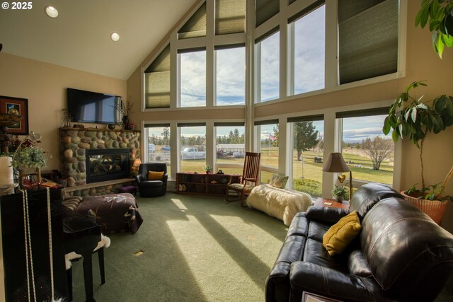 living room featuring high vaulted ceiling, a fireplace, a wealth of natural light, and carpet