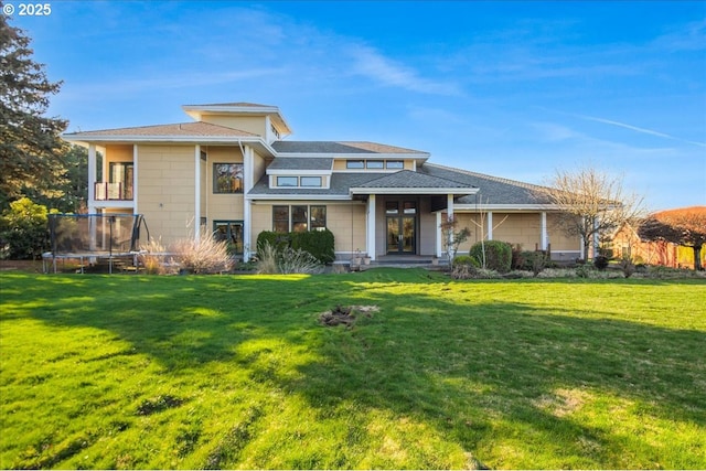 view of front of home with a trampoline and a front lawn