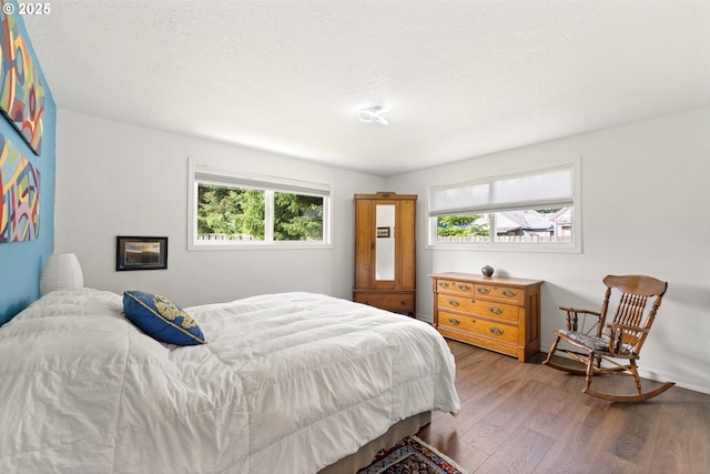 90726 Sanddollar Ln, Coos Bay, OR 97420 - bedroom featuring wood finished floors, multiple windows, and baseboards