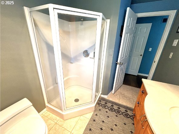 90726 Sanddollar Ln, Coos Bay, OR 97420 - bathroom with tile patterned flooring, a stall shower, and baseboards