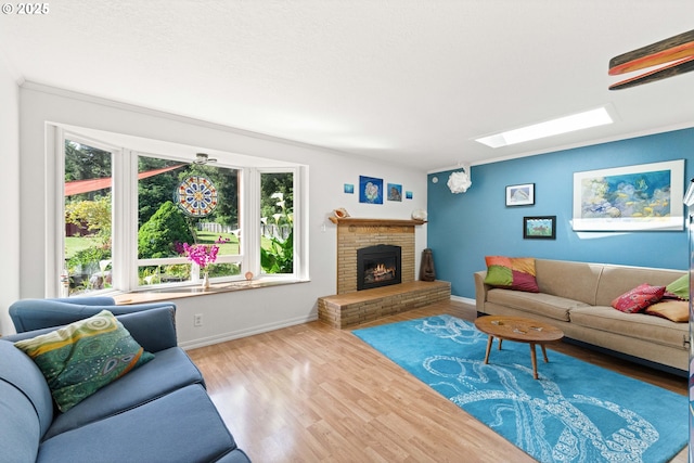 90726 Sanddollar Ln, Coos Bay, OR 97420 - living room featuring a skylight, baseboards, wood finished floors, and a brick fireplace