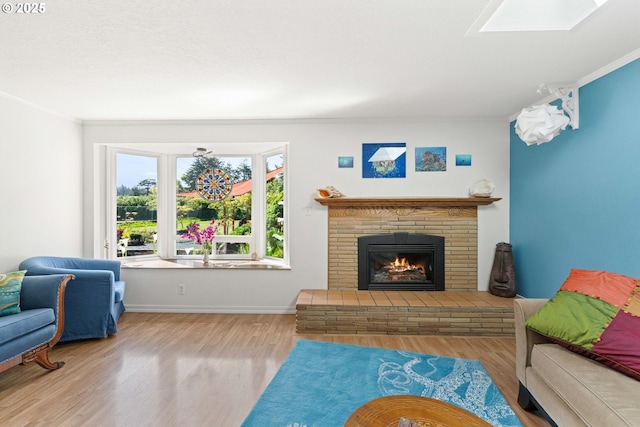 90726 Sanddollar Ln, Coos Bay, OR 97420 - living area with wood finished floors, a fireplace, ornamental molding, baseboards, and a skylight