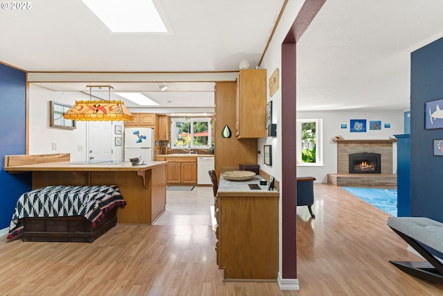 90726 Sanddollar Ln, Coos Bay, OR 97420 - kitchen featuring white appliances, a fireplace, a peninsula, and plenty of natural light