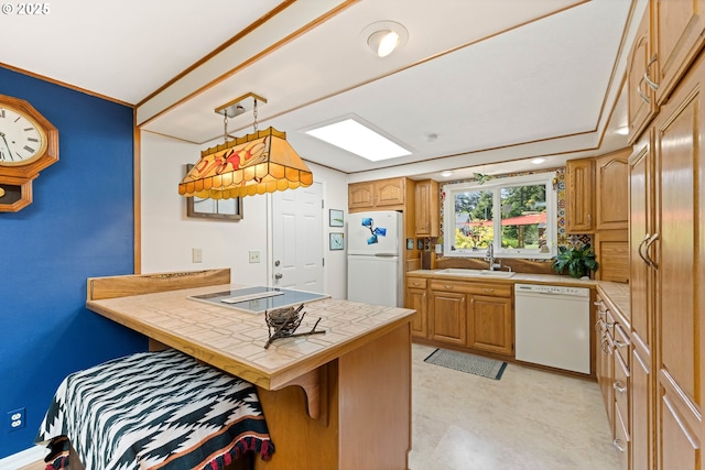 90726 Sanddollar Ln, Coos Bay, OR 97420 - kitchen featuring white appliances, tile counters, a sink, a peninsula, and a kitchen breakfast bar