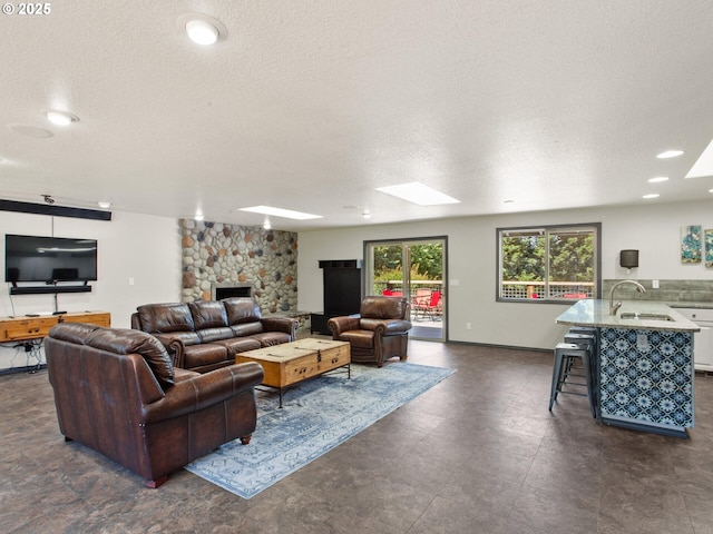 5417 N St, Washougal, WA 98671 - living area featuring a textured ceiling, a fireplace, a skylight, recessed lighting, and baseboards