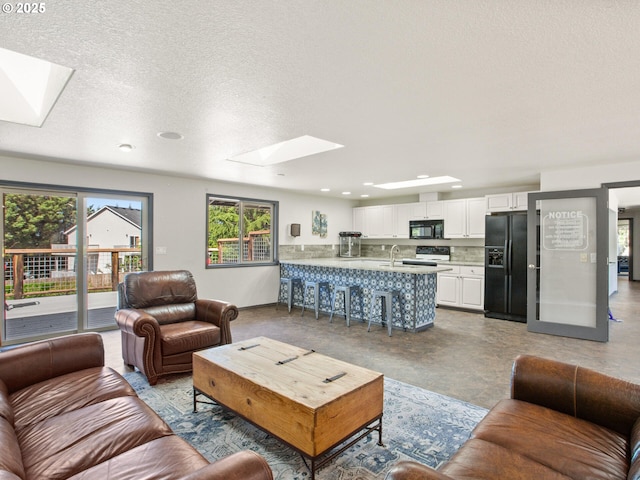 5417 N St, Washougal, WA 98671 - living area with a skylight, a textured ceiling, recessed lighting, and baseboards