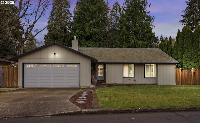 ranch-style house with driveway, fence, a yard, an attached garage, and a chimney