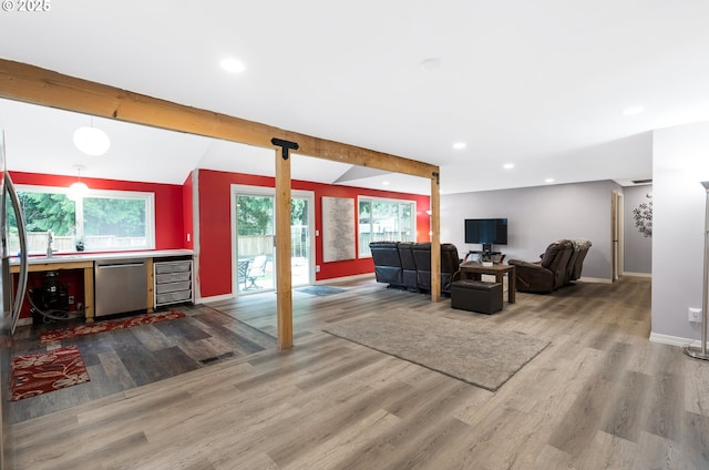 living area with recessed lighting, baseboards, a bar, and wood finished floors