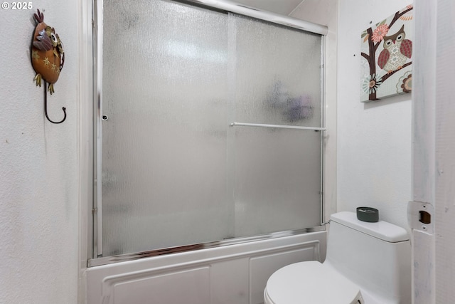 full bathroom featuring combined bath / shower with glass door and toilet