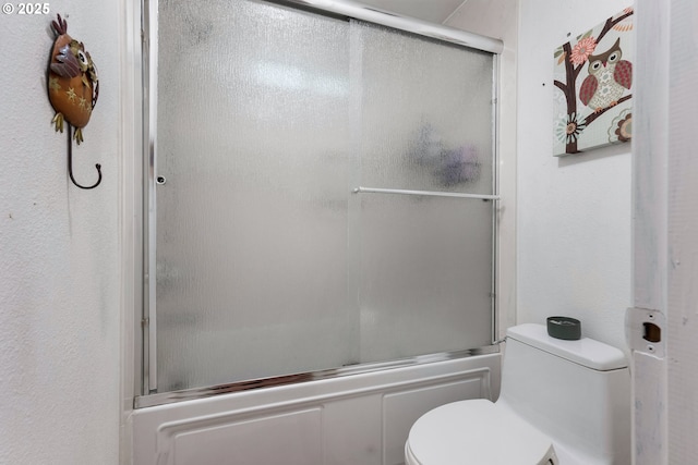 full bath featuring toilet and combined bath / shower with glass door