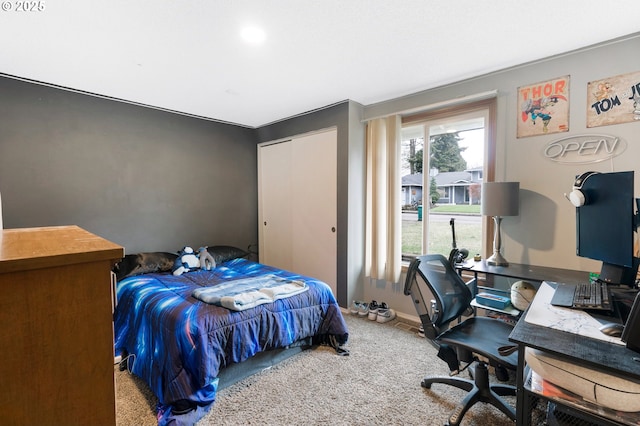 carpeted bedroom featuring baseboards and a closet