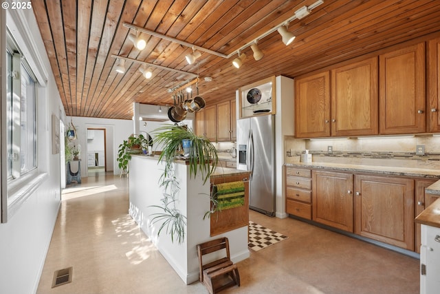 kitchen featuring wood ceiling, stainless steel refrigerator with ice dispenser, visible vents, light countertops, and track lighting