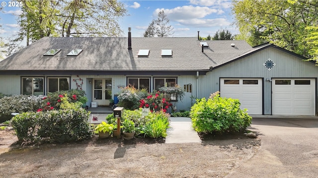 view of front of house featuring a shingled roof, an attached garage, and aphalt driveway