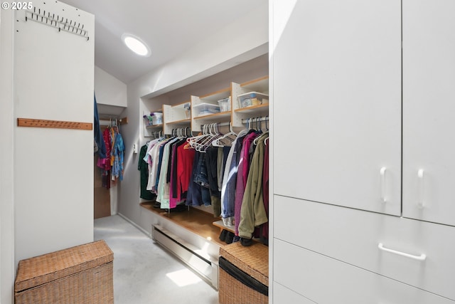 walk in closet with a baseboard heating unit and vaulted ceiling