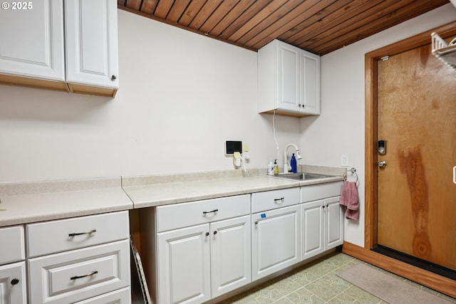 laundry room featuring wooden ceiling and a sink