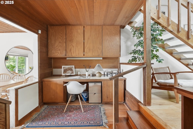 home office featuring wooden ceiling, built in desk, and light wood-style floors