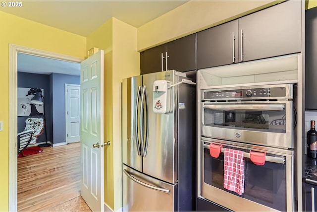 7680 SW 92nd Pl, Portland, OR 97223 - kitchen featuring stainless steel appliances, light wood finished floors, and baseboards