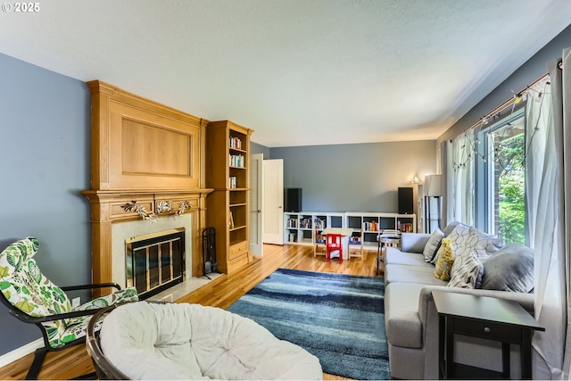 7680 SW 92nd Pl, Portland, OR 97223 - living area featuring a fireplace with flush hearth, wood finished floors, and baseboards