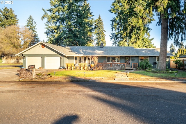 ranch-style home featuring a garage, a front lawn, and covered porch