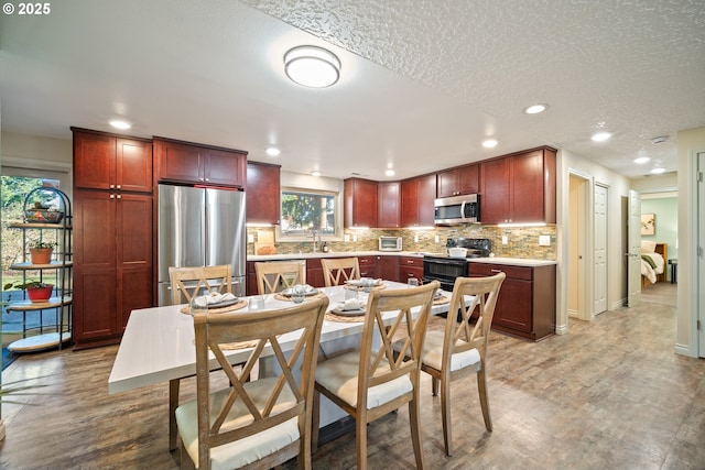 kitchen featuring sink, a textured ceiling, appliances with stainless steel finishes, and tasteful backsplash