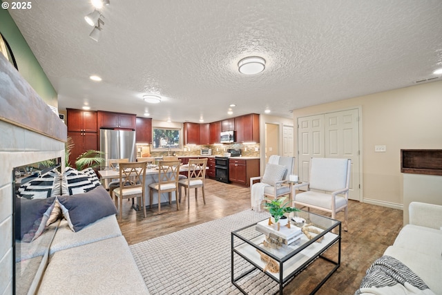 living room featuring hardwood / wood-style floors, a fireplace, and a textured ceiling