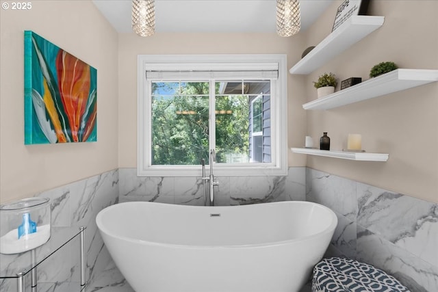 711 NW 94th Ter, Portland, OR 97229 - bathroom with tile walls, marble look tile flooring, a soaking tub, and wainscoting
