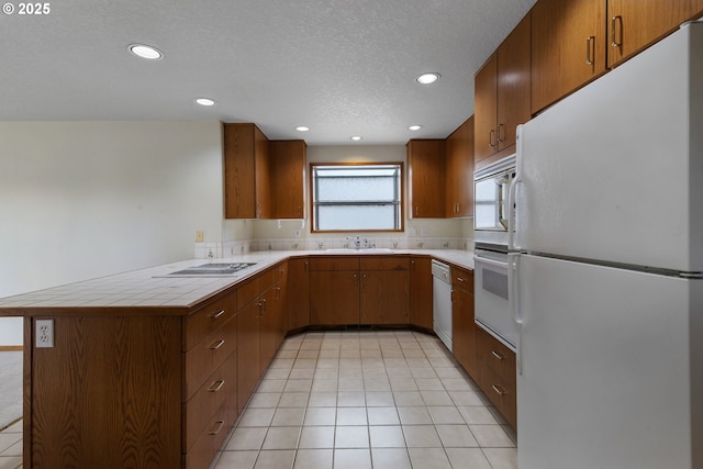 15917 NE Union Rd, Ridgefield, WA 98642 - kitchen featuring white appliances, a sink, recessed lighting, a peninsula, and tile countertops