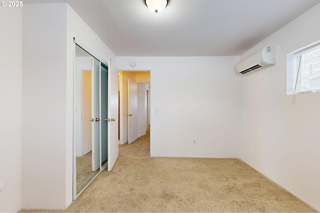 spare room with a wall mounted AC and light colored carpet