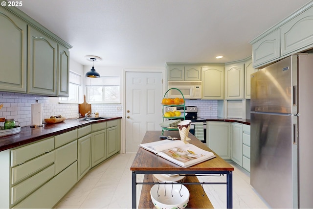 kitchen featuring green cabinetry, sink, tasteful backsplash, and stainless steel appliances