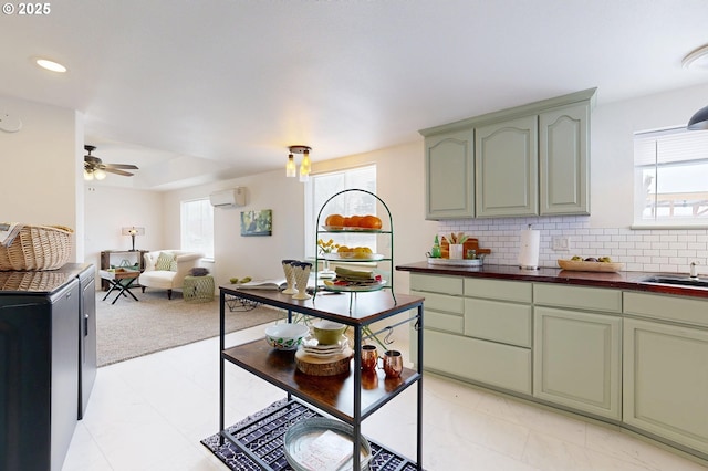 kitchen with a wall unit AC, tasteful backsplash, green cabinetry, and a healthy amount of sunlight