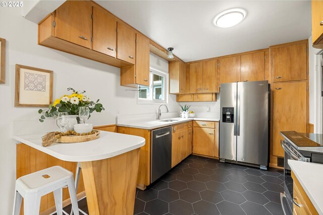 12405 SW Faircrest St, Portland, OR 97225 - kitchen featuring stainless steel appliances, light countertops, dark tile patterned floors, and a breakfast bar