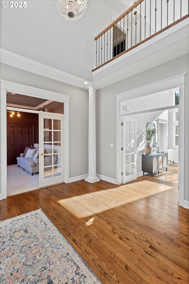 14218 NW Dunbar Ln, Portland, OR 97231 - entryway featuring ornate columns, wood finished floors, baseboards, and a towering ceiling