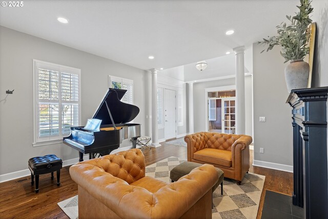 living room with ornate columns and dark hardwood / wood-style floors