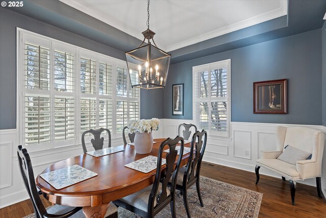 14218 NW Dunbar Ln, Portland, OR 97231 - dining space featuring a chandelier, a wainscoted wall, dark wood-type flooring, and a decorative wall