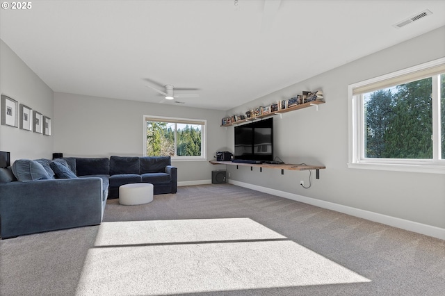 living room featuring baseboards, visible vents, ceiling fan, and carpet flooring