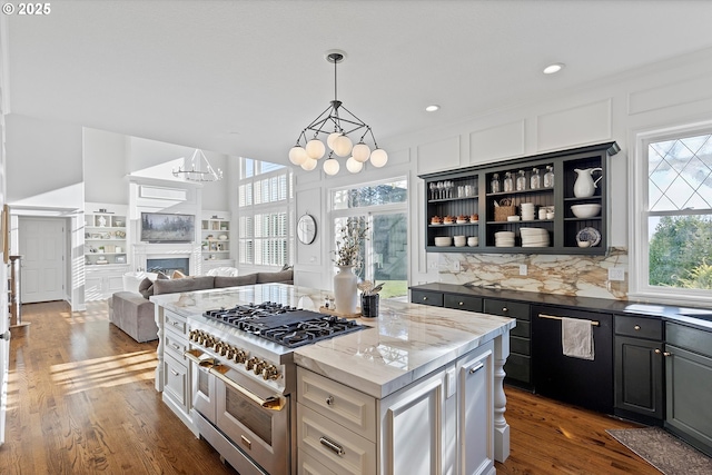 kitchen featuring a center island, dark hardwood / wood-style floors, dark stone counters, range with two ovens, and white cabinets