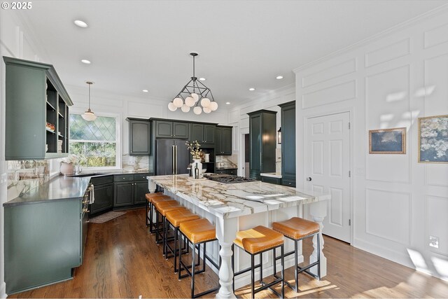 14218 NW Dunbar Ln, Portland, OR 97231 - kitchen with backsplash, a sink, a center island, a breakfast bar area, and stainless steel appliances