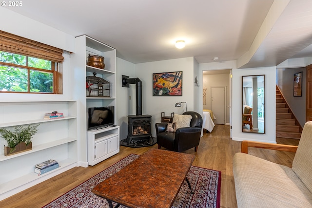8836 SW 56th Ave, Portland, OR 97219 - living area featuring a wood stove, stairway, light wood finished floors, and built in shelves