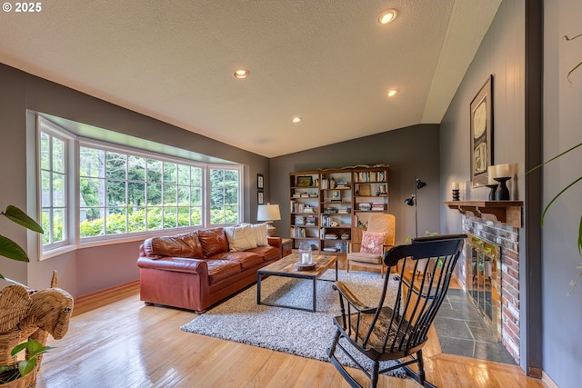 8836 SW 56th Ave, Portland, OR 97219 - living room featuring lofted ceiling, a textured ceiling, a fireplace, wood finished floors, and baseboards