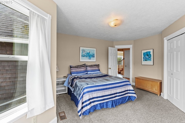 33310 Cape Kiwanda Dr, Pacific City, OR 97135 - bedroom with carpet flooring, a closet, baseboards, and a textured ceiling