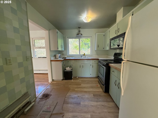 kitchen featuring white cabinets, a baseboard heating unit, white fridge, light hardwood / wood-style floors, and stainless steel electric range oven