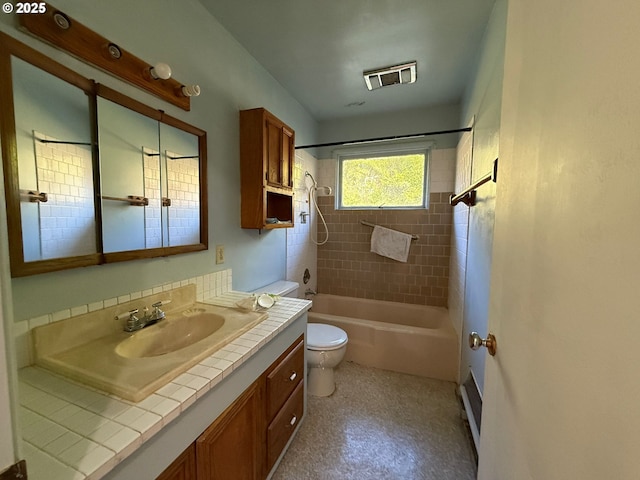 full bathroom featuring toilet, tiled shower / bath, and vanity