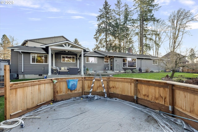 back of house featuring a yard and central AC unit