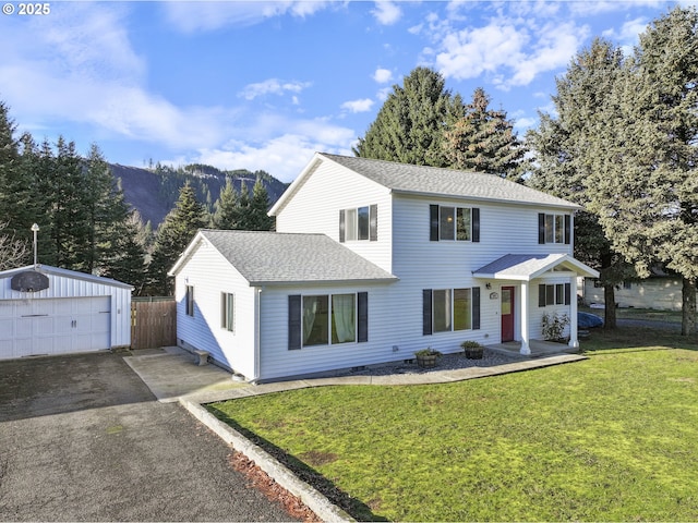 view of front of property with an outbuilding, a mountain view, a garage, and a front yard