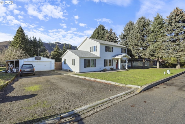 view of front of home featuring a mountain view, a garage, an outbuilding, and a front yard